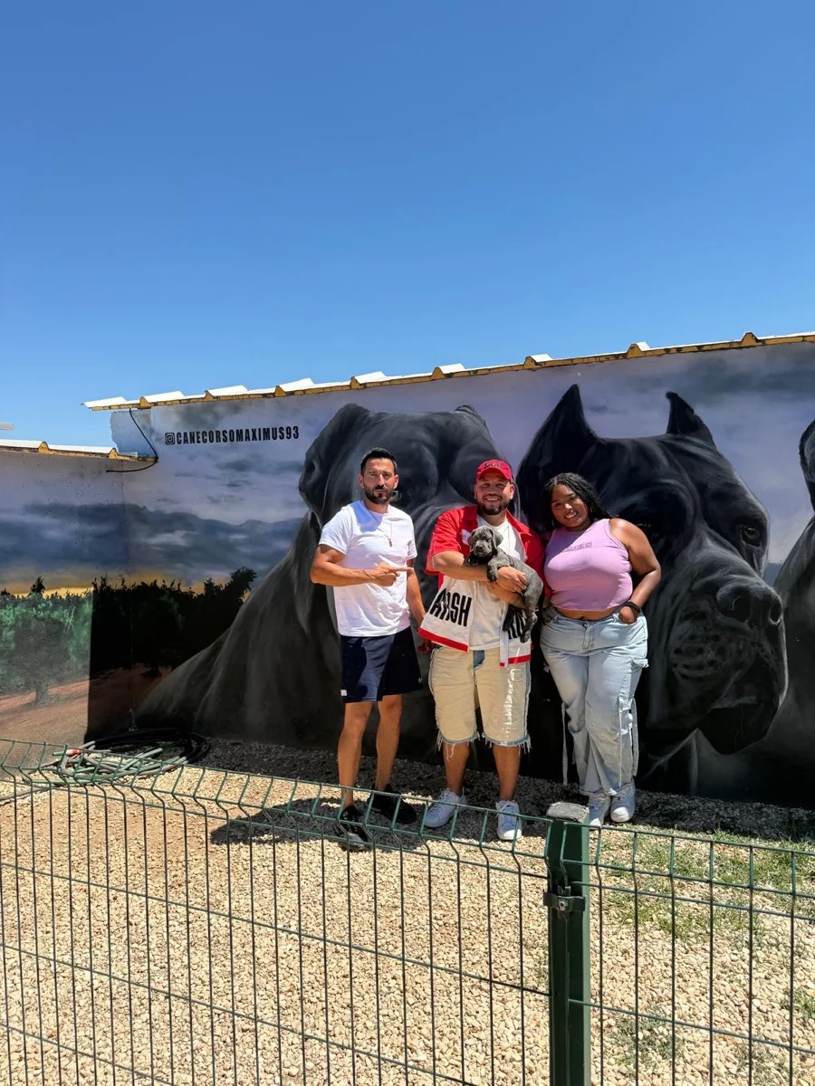 Familia posando con su cachorro Cane Corso